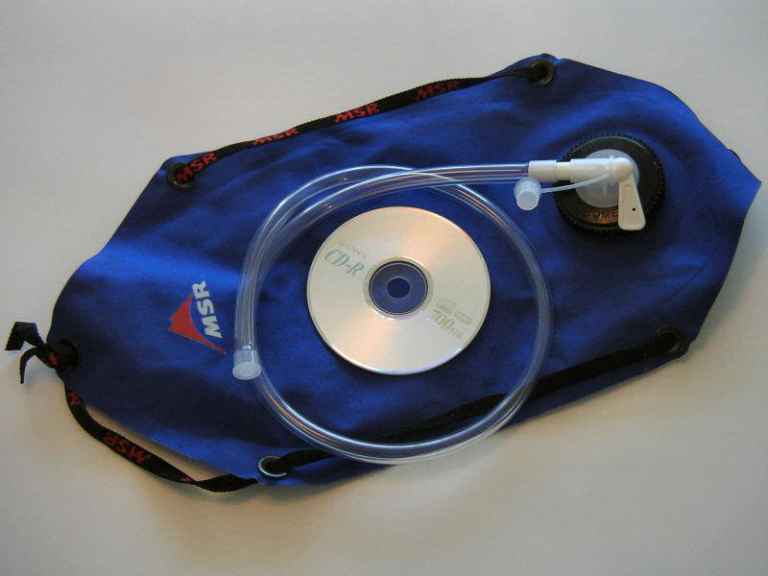 A picture of the MSR Shower kit attached to a bladder. CD is for sizing.